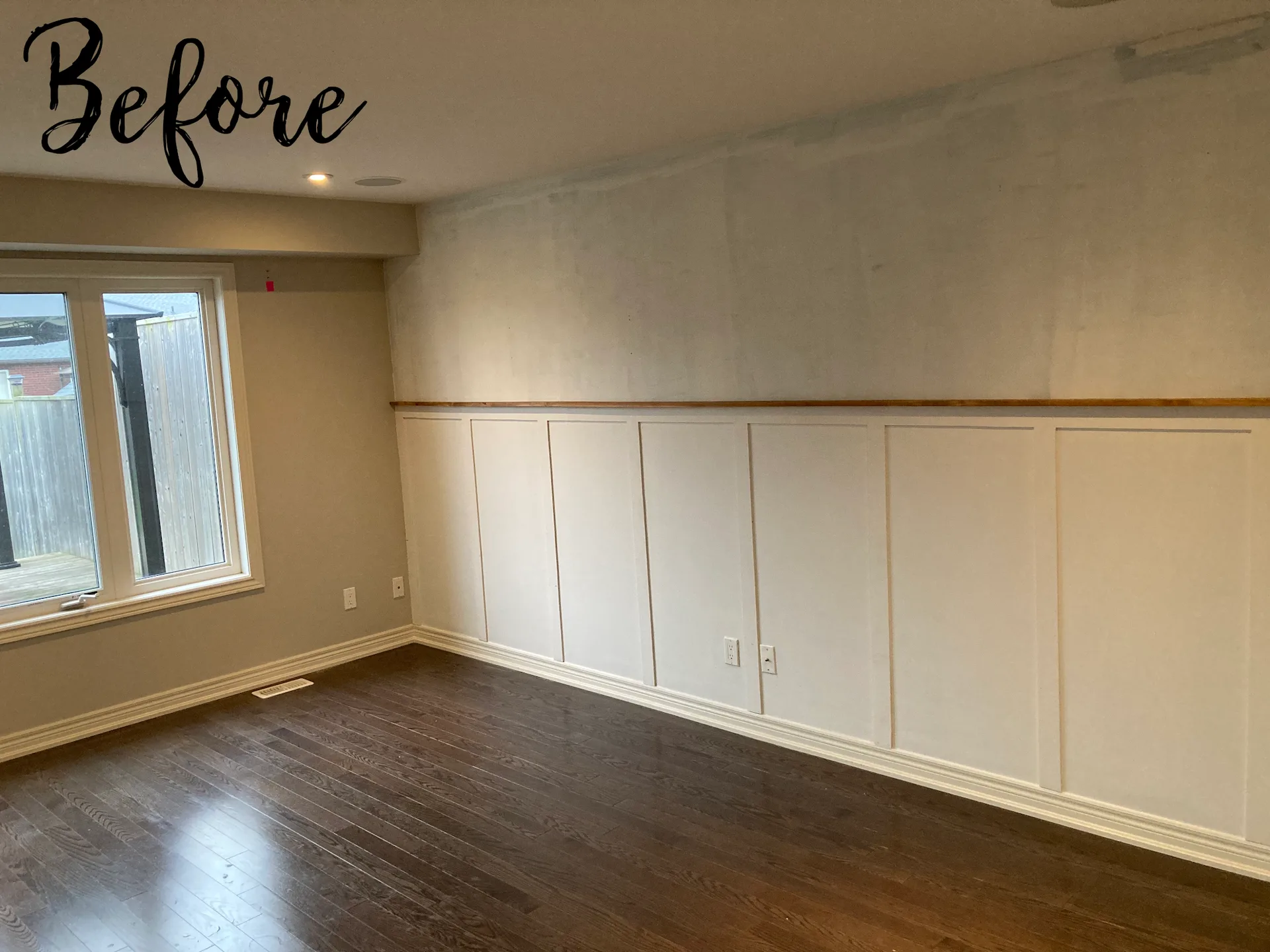Dining room with patchy walls and white wainscoting before repainting