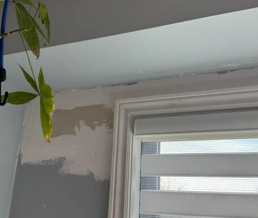 Drywall repair in progress above a window