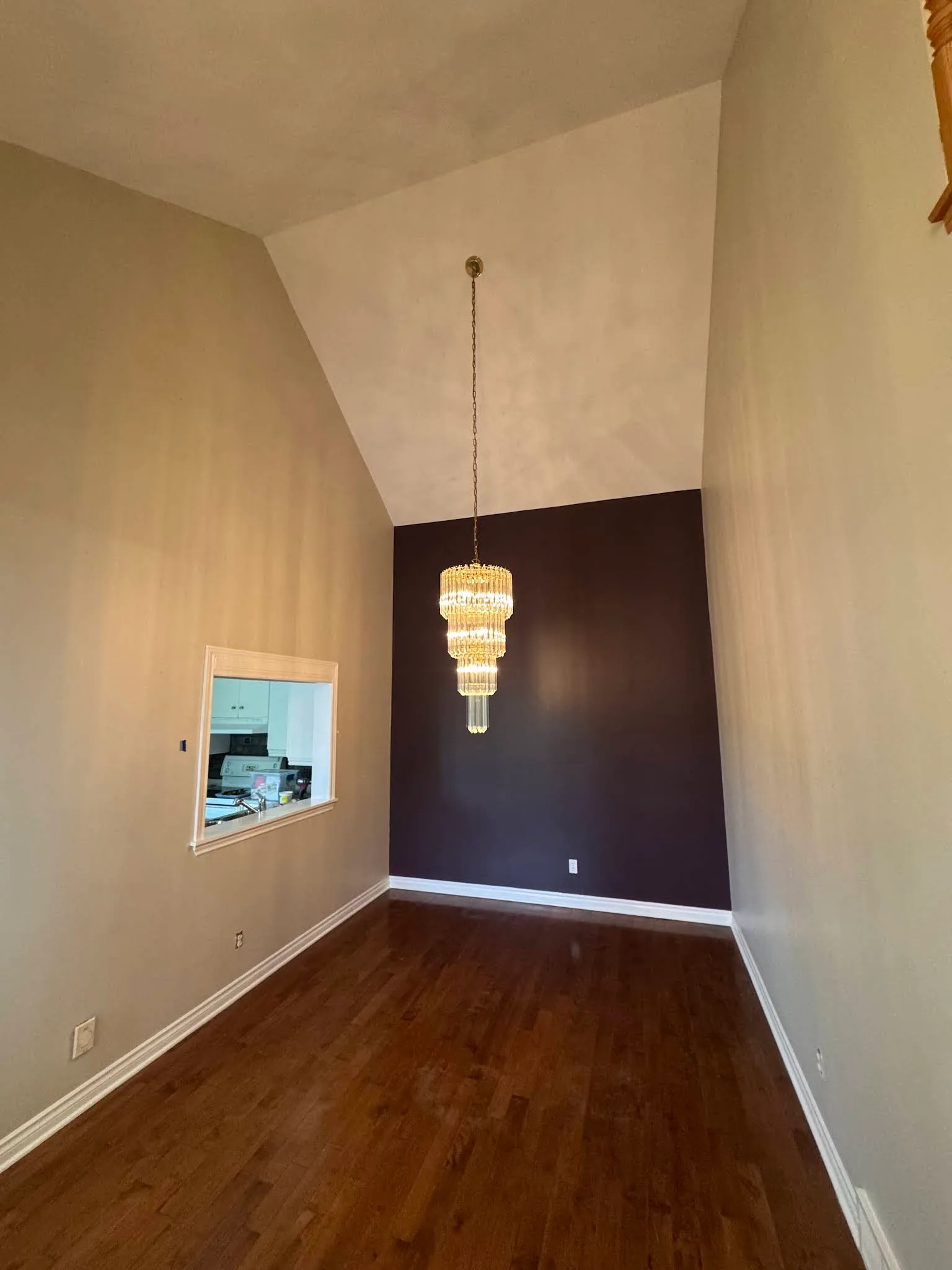 Narrow hallway finished with warm neutral walls and dark flooring