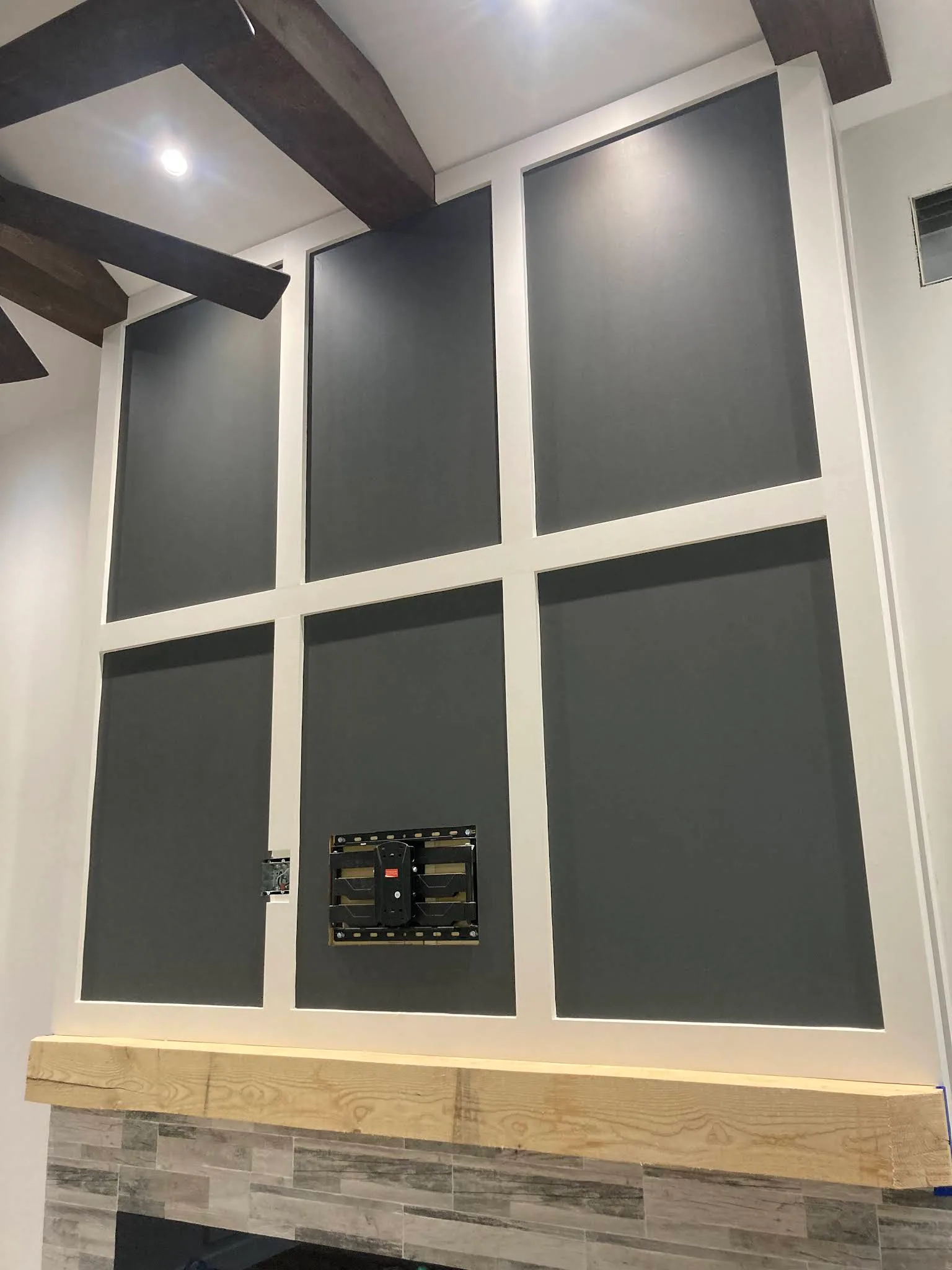 Built-in fireplace wall with contrasting dark panels and white trim