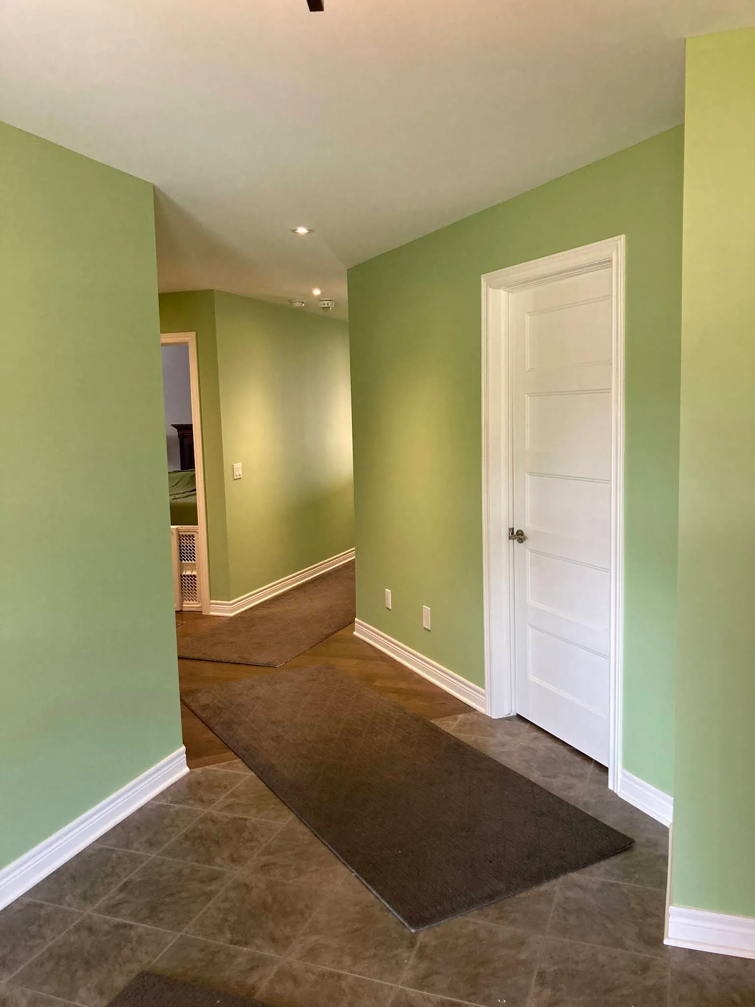 Hallway finished in soft green with crisp white doors and trim