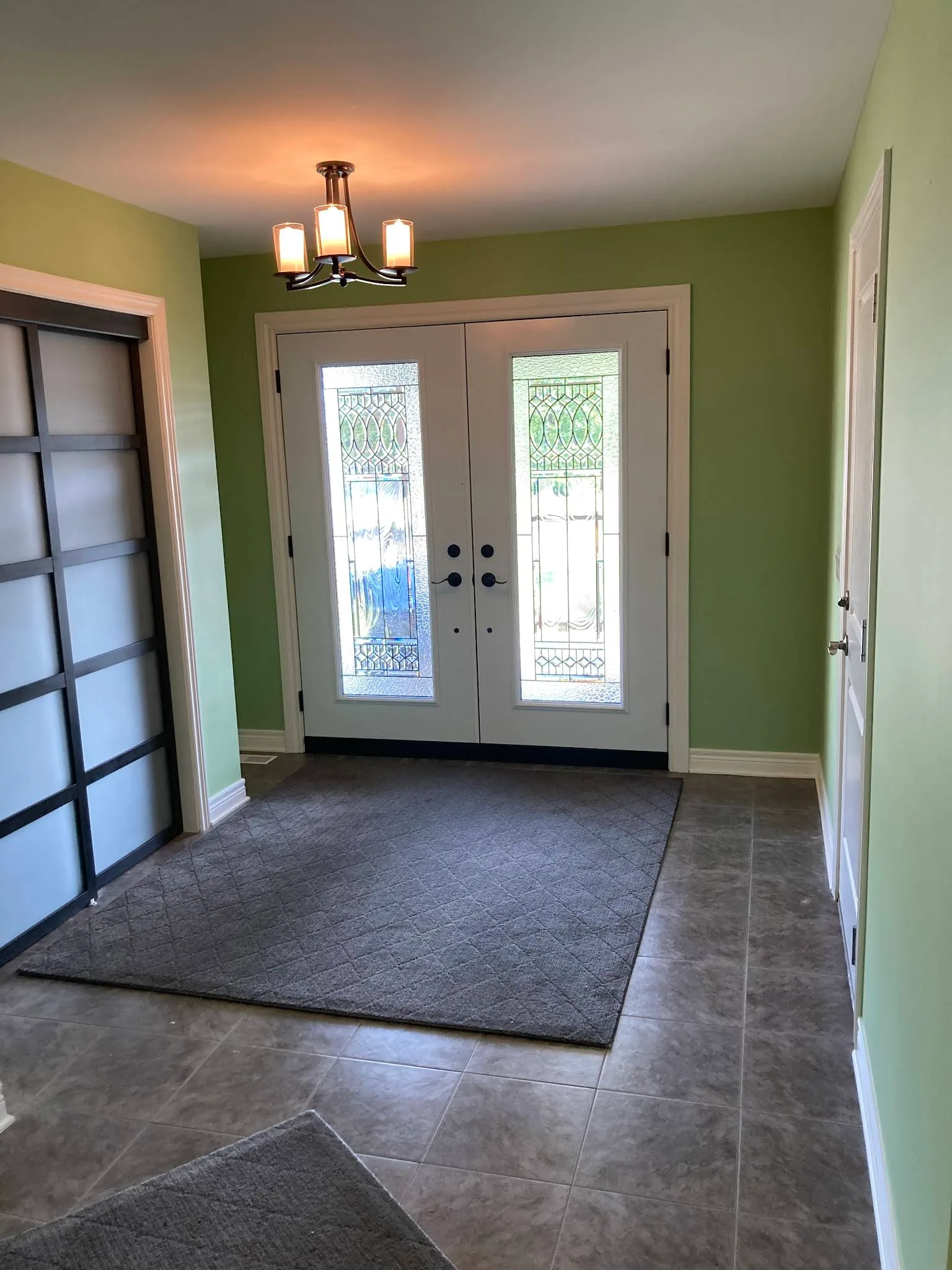 Entry hall finished with green walls and clean white trim
