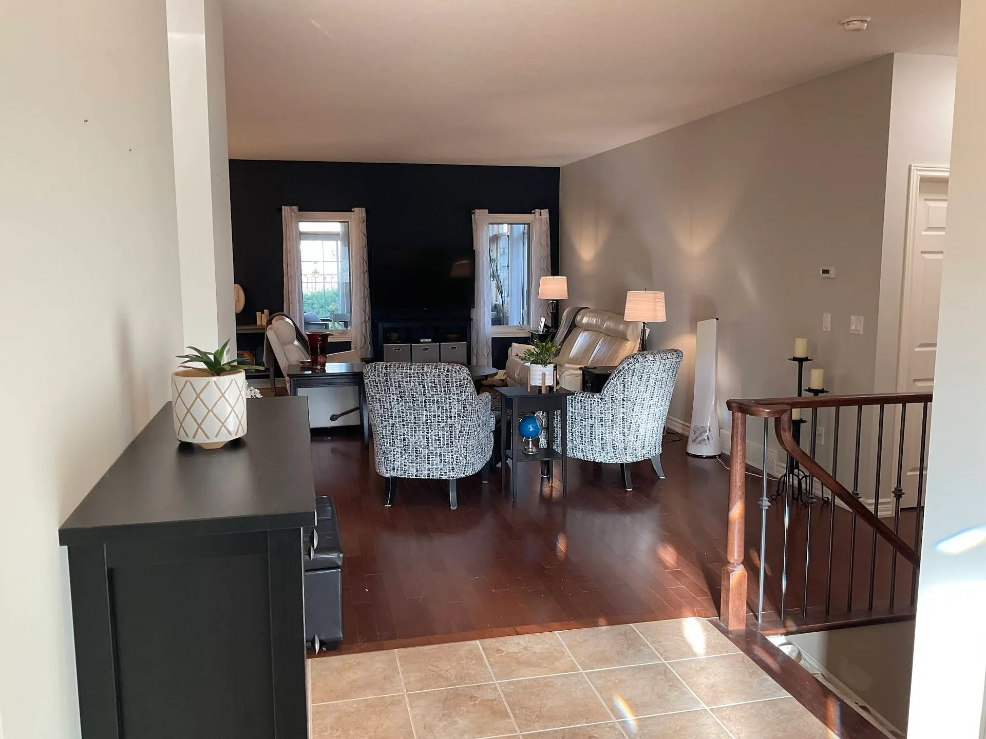 Open dining and living area with warm grey walls and dark floors